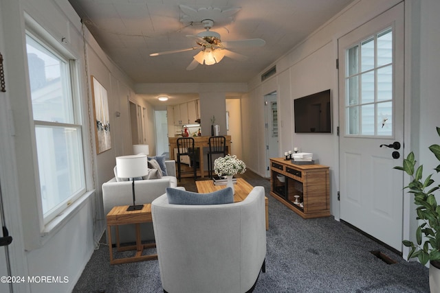 carpeted living room with ceiling fan