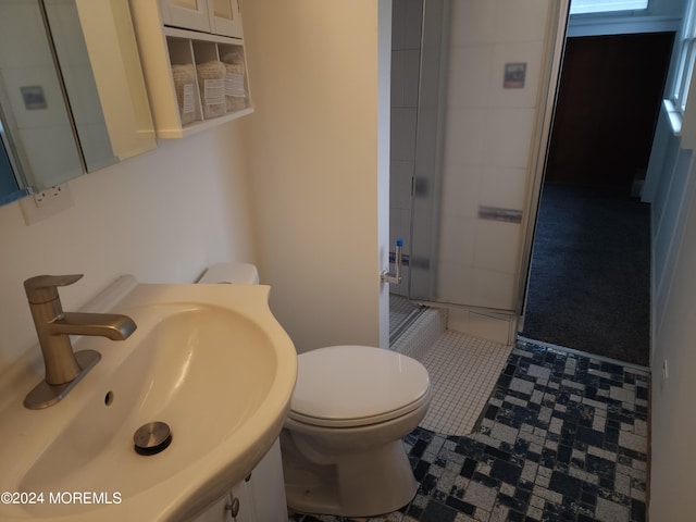 bathroom with a shower with shower door, vanity, and toilet