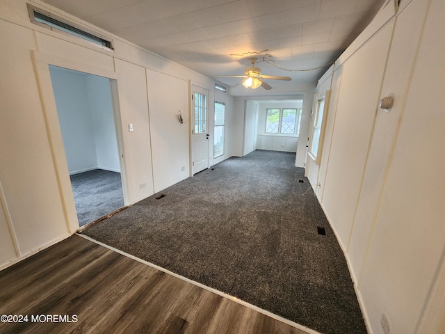 interior space with ceiling fan and dark carpet