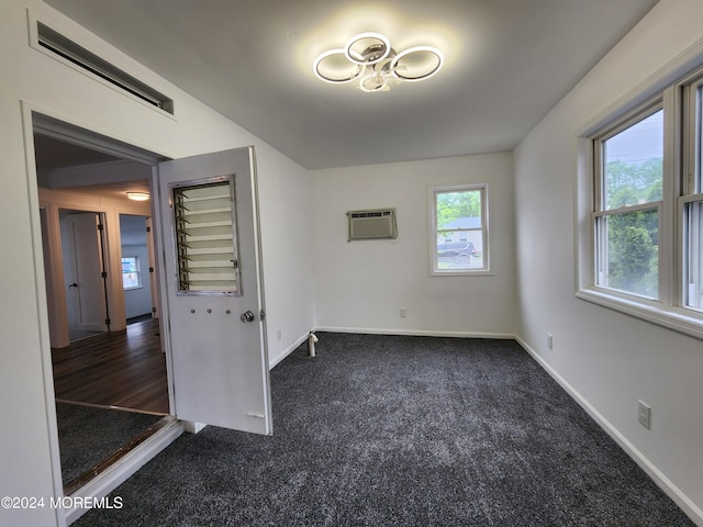 empty room featuring dark carpet and a wall mounted AC