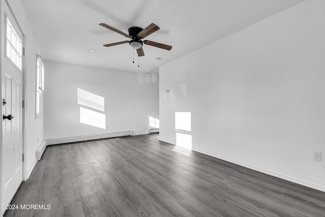 empty room with dark wood-type flooring, ceiling fan, and a baseboard heating unit