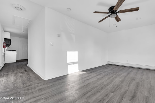 spare room featuring ceiling fan, washer / clothes dryer, a baseboard heating unit, and light wood-type flooring