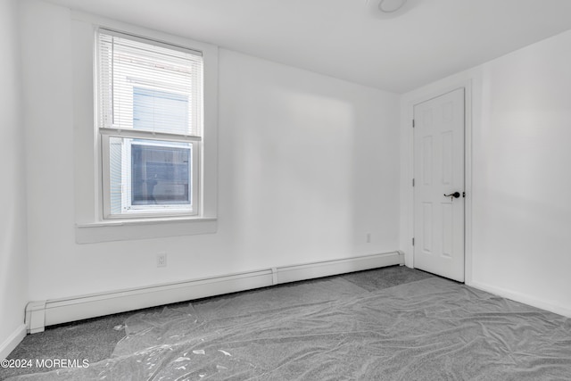 carpeted empty room with baseboard heating