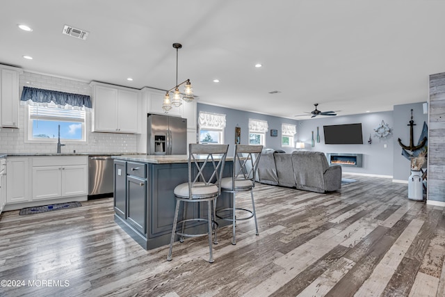 kitchen with white cabinetry, stainless steel appliances, and a kitchen island