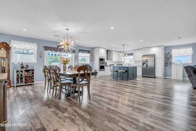 dining room with an inviting chandelier, light hardwood / wood-style floors, and sink