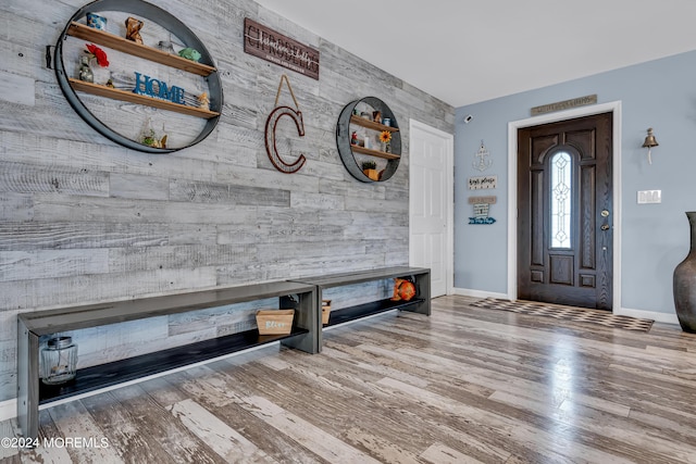 foyer entrance with wood-type flooring and wood walls