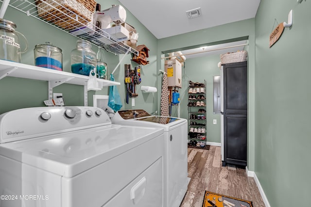 laundry room with washer and dryer, light hardwood / wood-style flooring, and water heater