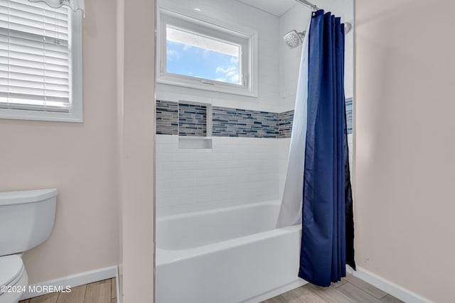 bathroom featuring hardwood / wood-style floors, toilet, and shower / bathtub combination with curtain