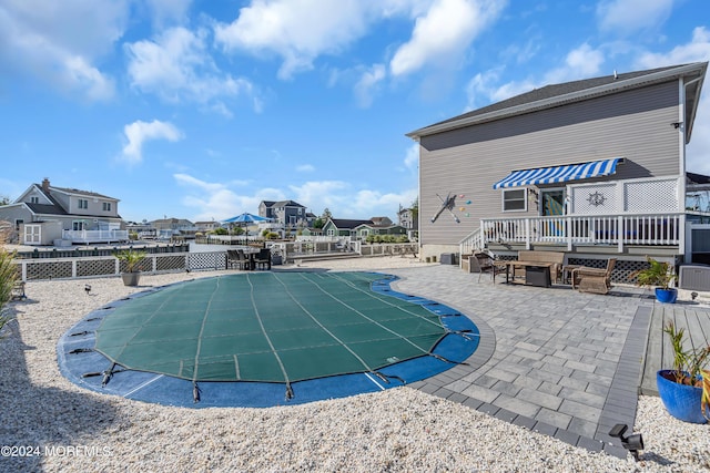 view of pool featuring a patio area and a wooden deck