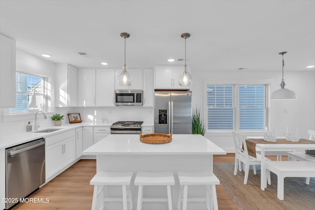 kitchen with sink, a center island, white cabinets, and appliances with stainless steel finishes