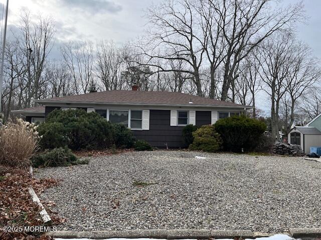 view of front of house featuring a storage unit, an outdoor structure, and driveway