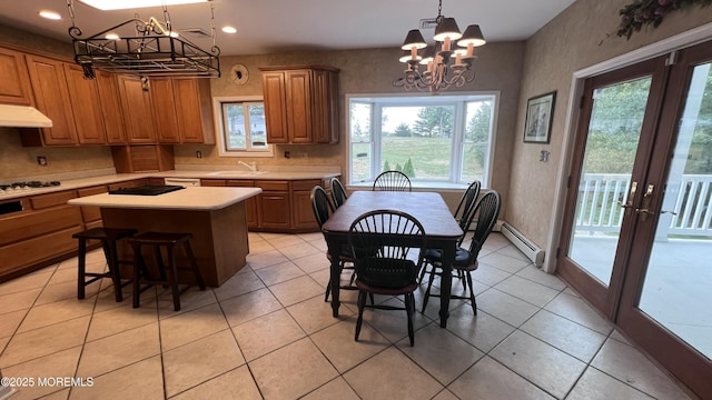 dining space featuring a notable chandelier, sink, light tile patterned floors, french doors, and a baseboard radiator