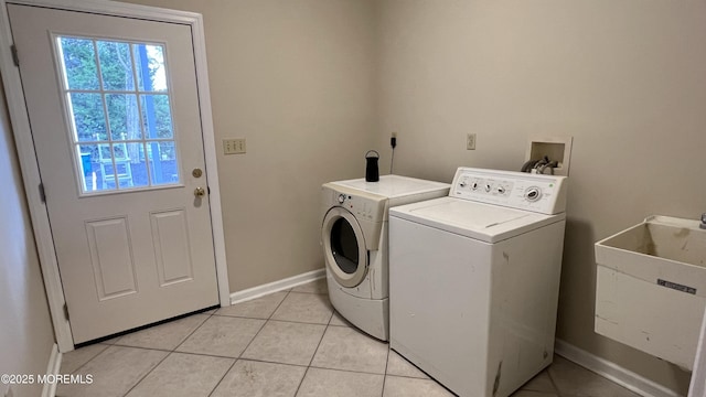 laundry area with sink, light tile patterned floors, and washing machine and dryer