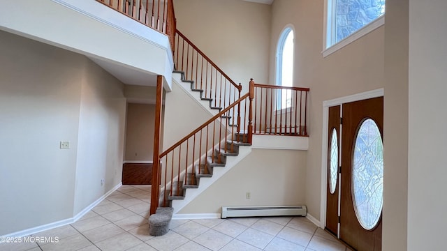 tiled entrance foyer with a high ceiling and a baseboard radiator