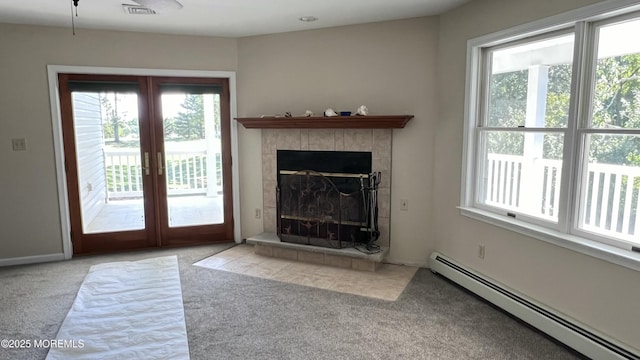 unfurnished living room featuring light carpet, french doors, a tile fireplace, and a baseboard radiator