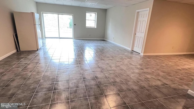 unfurnished room featuring a drop ceiling