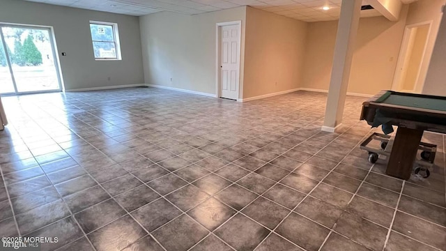 basement with billiards, a drop ceiling, and dark tile patterned flooring