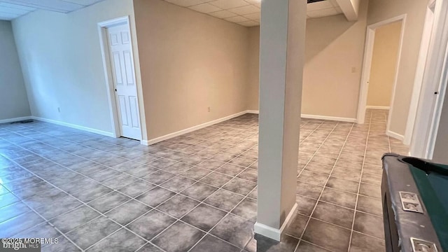 basement with tile patterned floors and a drop ceiling