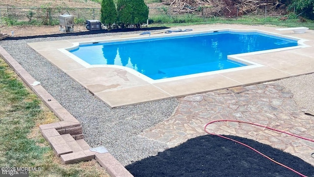 view of swimming pool with a diving board