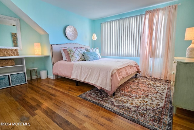 bedroom featuring hardwood / wood-style floors and vaulted ceiling