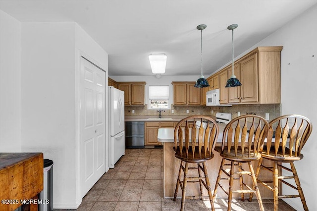 kitchen with backsplash, sink, white appliances, and light brown cabinets