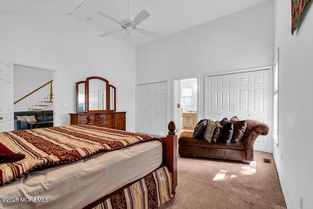 carpeted bedroom with high vaulted ceiling, ensuite bath, and ceiling fan