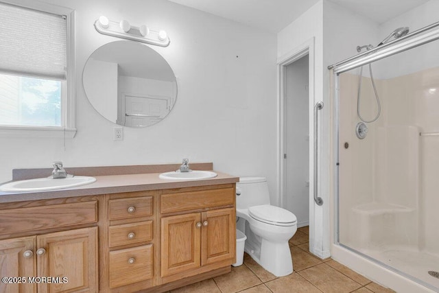 bathroom featuring a shower with shower door, vanity, tile patterned floors, and toilet