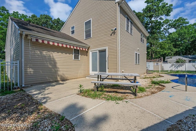 rear view of property with a patio area and a fenced in pool