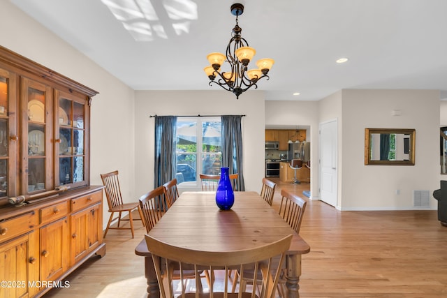 dining room featuring light wood-type flooring and a chandelier