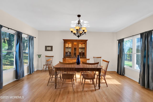 dining room with light wood-type flooring and a chandelier