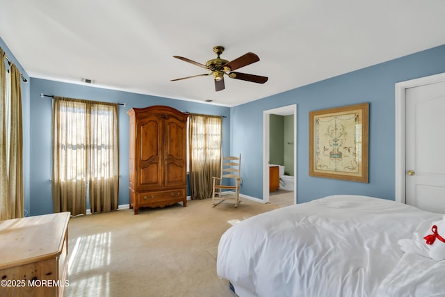 bedroom featuring ceiling fan, ensuite bathroom, and light carpet