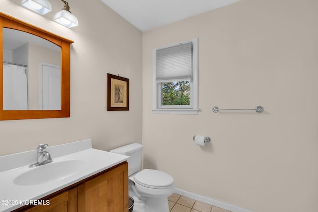 bathroom with toilet, vanity, and tile patterned flooring