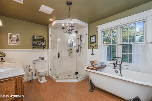 full bathroom with vanity, toilet, a notable chandelier, hardwood / wood-style flooring, and independent shower and bath