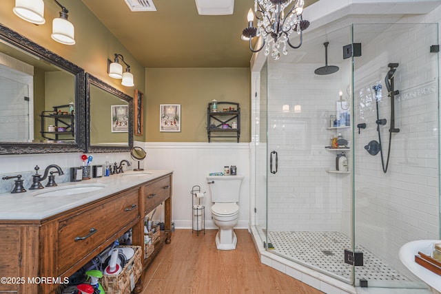 bathroom with toilet, hardwood / wood-style flooring, walk in shower, a chandelier, and vanity