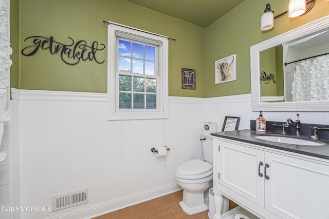 bathroom with wood-type flooring, toilet, and vanity