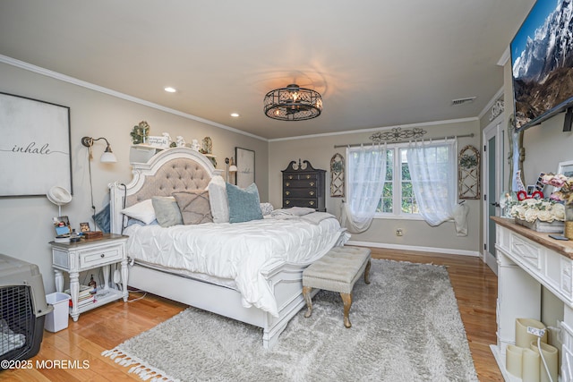 bedroom with an inviting chandelier, ornamental molding, and hardwood / wood-style flooring