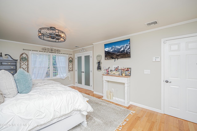 bedroom featuring french doors, ornamental molding, and hardwood / wood-style flooring