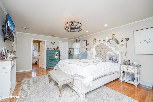 bedroom with light wood-type flooring, ensuite bathroom, and crown molding