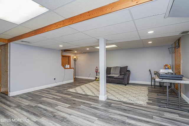 basement featuring a paneled ceiling and wood-type flooring