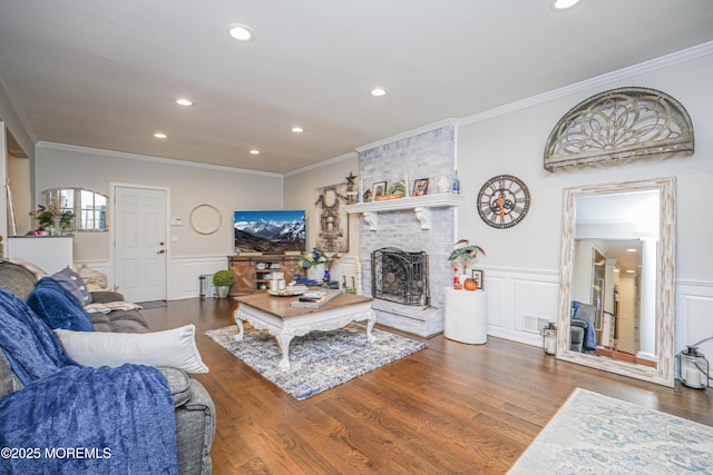 living room featuring a brick fireplace, dark hardwood / wood-style flooring, and crown molding