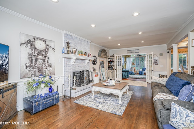 living room with dark hardwood / wood-style floors, ornamental molding, french doors, and a brick fireplace