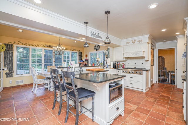 kitchen featuring a kitchen breakfast bar, white cabinetry, hanging light fixtures, and built in microwave