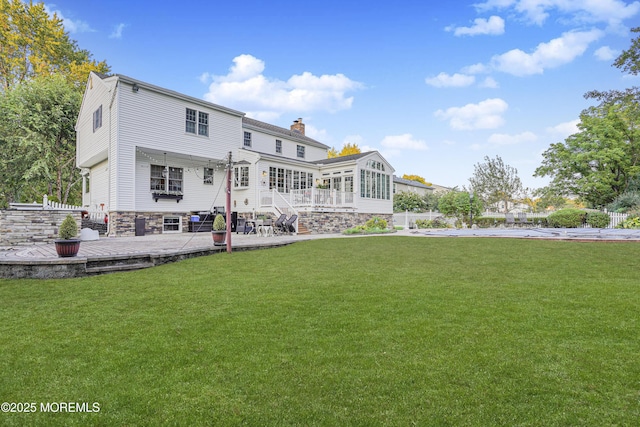 back of house with a sunroom, a yard, and a patio