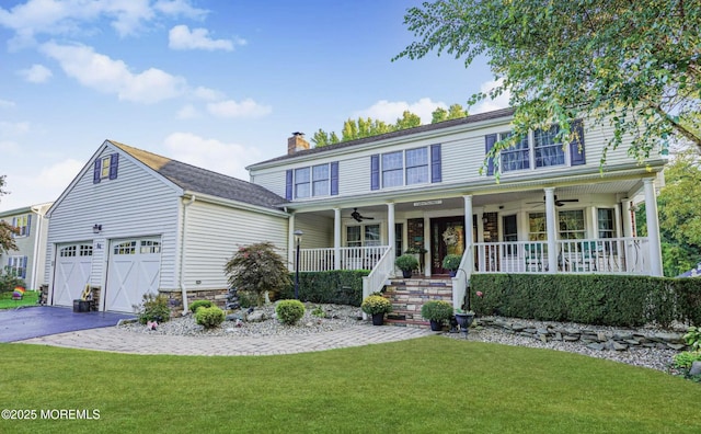 view of front of home with covered porch, a front yard, a garage, and ceiling fan