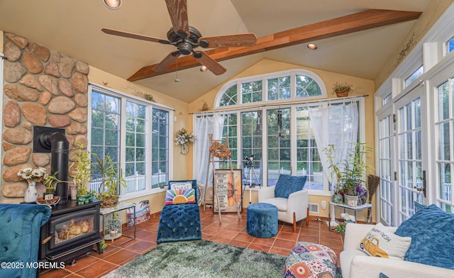 sunroom featuring ceiling fan, a wood stove, and lofted ceiling with beams