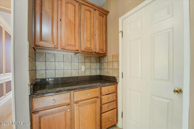 kitchen featuring backsplash and dark stone counters