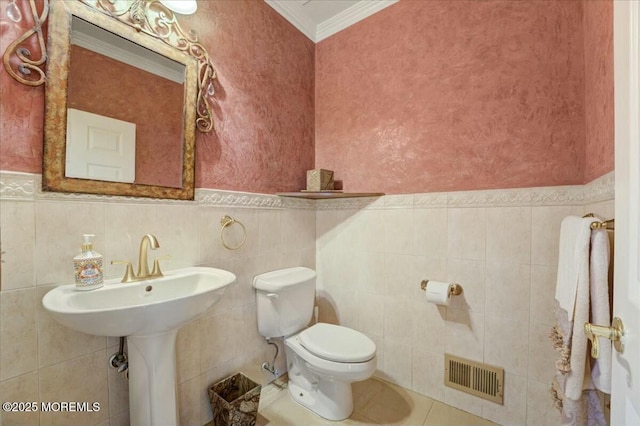 bathroom with toilet, ornamental molding, tile walls, and tile patterned flooring