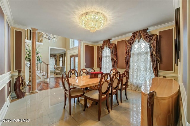 tiled dining space with decorative columns, ornamental molding, and a chandelier