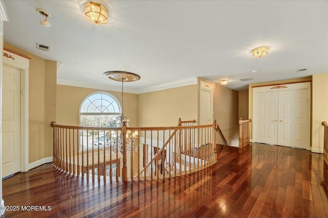 corridor with dark hardwood / wood-style floors and ornamental molding