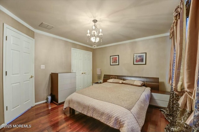 bedroom with dark wood-type flooring, crown molding, and an inviting chandelier